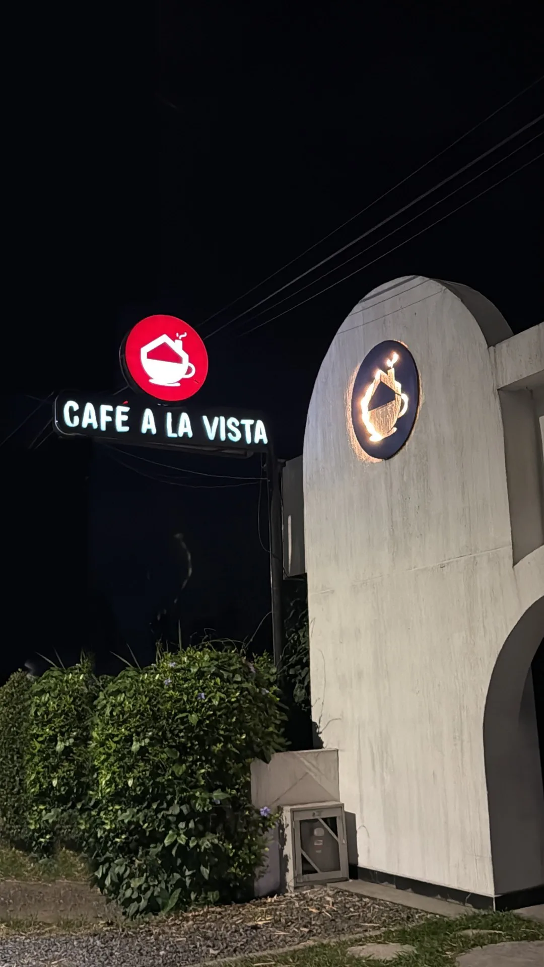 Fachada de Café a la Vista de noche con su aviso iluminado
